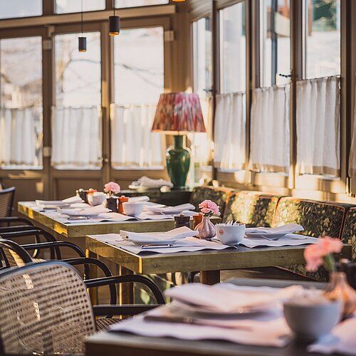 Beginnen Sie Ihren Tag in unserem lichtdurchfluteten Frühstückspavillon im Spa & Resort Bachmair Weissach, während...